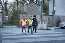 Drei Kinder überqueren den Zebrastreifen