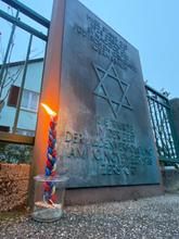Gedenktafel zur Erinnerung an die Synagoge, davor eine Kerze