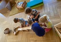 Spielende Kinder mit einer Holzmurmelbahn