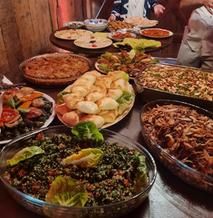 Ein Buffet aus syrischen Speisen in Schüsseln und auf Platten 