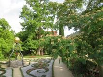 Parkanlage mit barocken Pflanzelementen um einen Ziehbrunnen