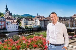 Bürgermeister Julian Christ vor der Kulisse der Gernsbacher Altstadt Der Bürgermeister steht auf dem Rathausbalkon, die Gernsbacher Altstadt im Hintergrund