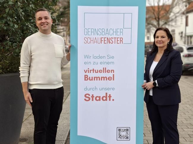 Bürgermeister Julian Christ und Wirtschaftsförderin Nicoletta Arand freuen sich über das neue Bonusheft des Gernsbacher Schaufensters, einem Projekt der städtischen Wirtschaftsförderung. Ein Mann und eine Frau mit einem Banner in der Mitte