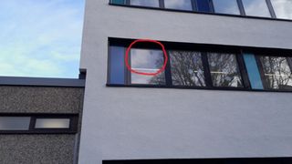 Der Schaden stammt offensichtlich von einem Steinwurf. Durch Steinwurf beschädigte Fensterscheibe an Schulgebäude