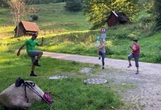 Drei Personen bei Fitnessübungen auf einem Wanderweg 