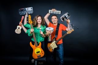 Eine Frau und ein Mann, die verschiedene Musikinstrumente in der Hand haben.
