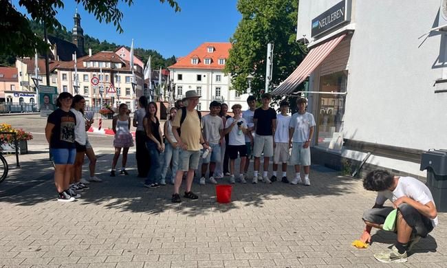 Ein Schüler säubert vor dem Haus Bleichstraße 2 den Stolperstein für Hermann Nachmann, den letzten Vorsteher der Synagogengemeinde Gernsbach