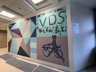 Die Klasse 9a ist stolz auf das Ergebnis ihrer Wandneugestaltung. Frisch gestaltete Wand mit Schriftzug, grafischen Mustern und Von-Drais-Portrait