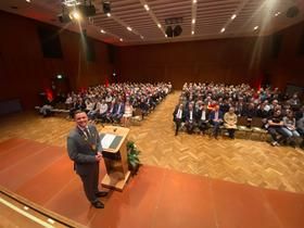 Bürgermeister auf der Bühne, großes Publikum im Saal