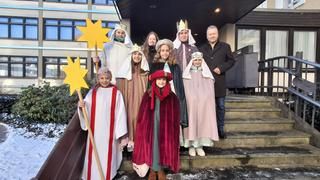 Eine Sternsingergruppe mit Bürgermeisterstellvertreter auf der Rathaustreppe 