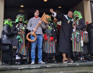 Närrisch gekleidete Personen auf der Treppe, 1 Mann mit 1 großem Schlüssel 