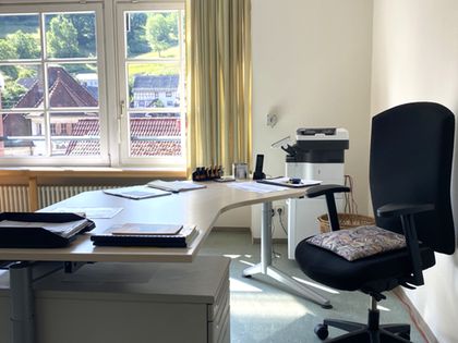 Büro des Ortsvorstehers mit Schreibtisch, Stuhl und Blick aus dem Fenster.