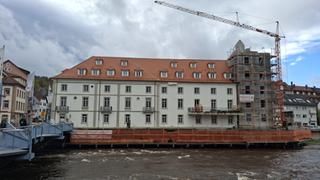 Brückenmühle in der Bauphase. Haus mit Turmrohbau mit Kran an der Murg.