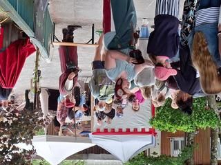 Männer als Gaukler mit Besucherinnen und Besuchern auf einem Platz