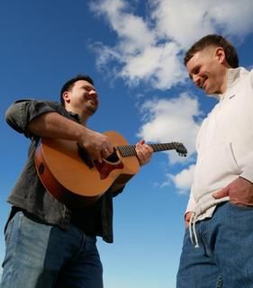 Patrik Heid und Lucca Strolz präsentieren handgemachte Akustikmusik mit Charakter. Zwei Musiker vor blauem Himmel