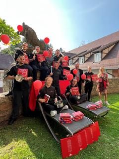 Das gesamte Team ist stolz auf die erneute Auszeichnung. Das Küchenteam mit roten Ballons und den Auszeichnungen.