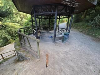 Holzschutzhütte im grünen Kurpark, verkohltes Holz.
