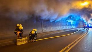2 Feuerwehrleute bauen die Wasserversorgung im verrauchten Tunnel auf. 