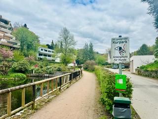 Hundekotbeutel-Spender stehen an vielen Stellen zur kostenfreien Nutzung zur Verfügung. Blick in den Park von der Station für Hundekotbeutel