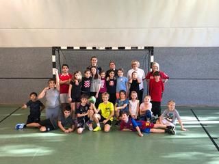 Kinder stehen vor dem Tor in einer Turnhalle