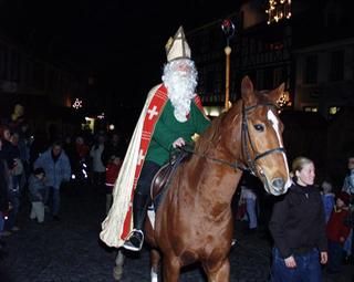 St. Nikolaus mit Mitra und Hirtenstab reitet durch die Altstadt
