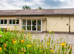 Die Grundschule Staufenberg mit dem Schulhof, auf dem mit Straßenkreide Bilder gemalt sind.