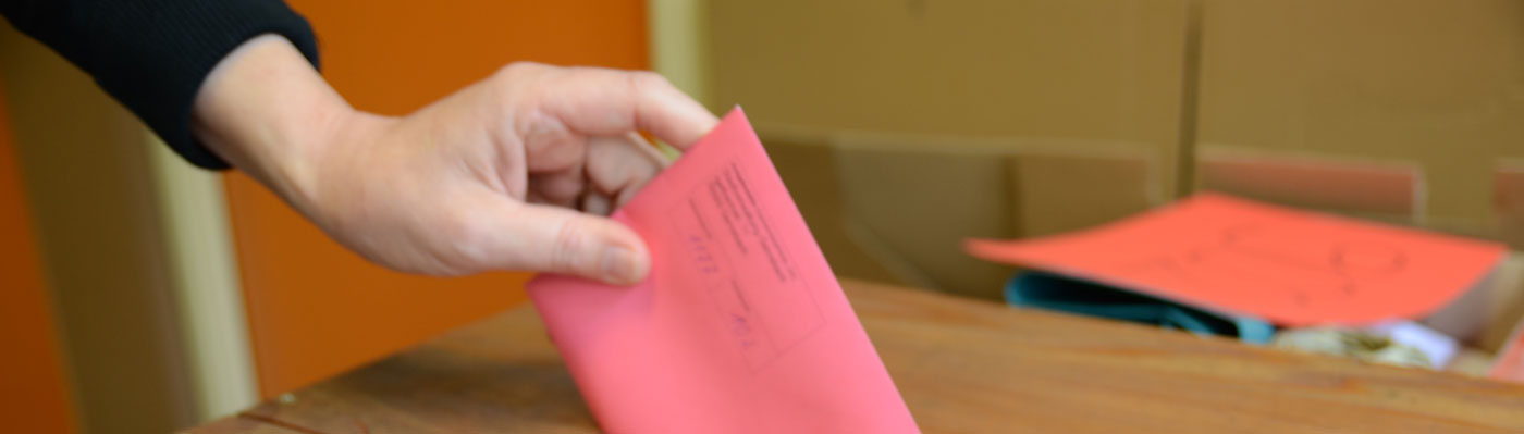 Wahl Wahlumschlag wird in Wahlurne gesteckt