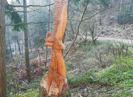 Aus einem Baumstumpf gesägte Skulptur eines fliegenden Adlers