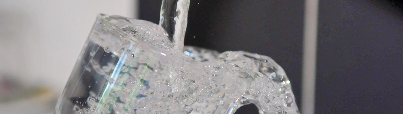 Wasser sprudelt in Glas
