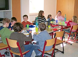 Kinder sitzen am Tisch beim Essen