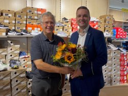 Bürgermeister Julian Christ (r) gratuliert Ernst Fischer (l) ganz herzlich zu 25 Jahren Sport Fischer am Standort Salmenplatz und wünscht weiterhin alles Gute. Bürgermeister Julian Christ (rechts im Bild) überreicht Ernst Fischer (links im Bild) einen Blumenstrauß zum 25. Jubiläum.