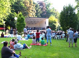 Besucher lauschen gemütlich auf Picknickdecken im Grünen einem Konzert im Kurpark