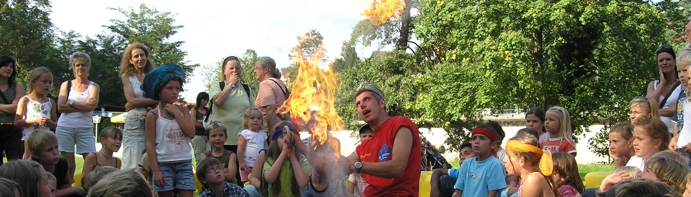 Kinder bestaunen auf der Murginsel einen Jongleur mit brennenden Fackeln