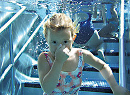 Ein Mädchen taucht im Schwimmbad unter