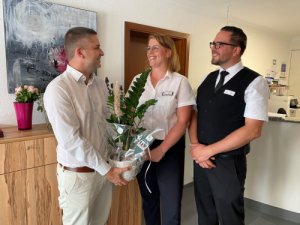 Bürgermeister Christ (links) gratuliert den Eheleuten Tatjana (mittig) und Stefan Merlin (rechts) zur gelungenen Unternehmensnachfolge.