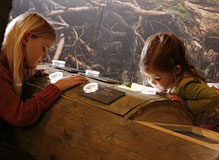 Zwei Mädchen schauen in die Vergrößerungsgläser an einem Baummodell