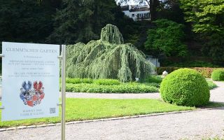 Eingang des Clemm'schen Gartens Infotafel am Eingang, im Hintergrund die Anlage mit ihren Pflanzen