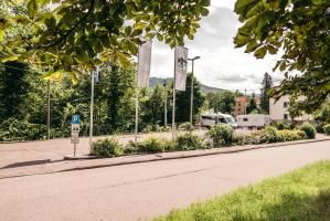 Sitzplatz Wohnmobilstellplatz Murginsel Vier Personen sitzen am Tisch, im Hintergrund die Wohnmobile