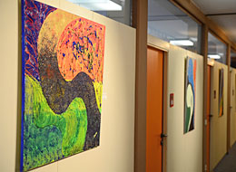 weiter zu Kunstausstellung im Rathaus Bei einer Kunstausstellung im Rathaus hängen farbenfrohe Gemälde an den Wänden des Rathausflures