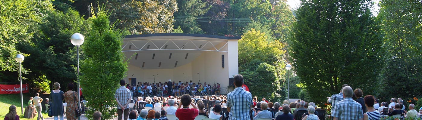 Konzert im Kurpark Besucher lauschen gemütlich auf Picknickdecken im Grünen einem Konzert im Kurpark