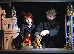 weiter zur Puppentheaterwoche Die Puppenspieler von Theater con Cuore im Bühnenbild vor Notre Dame spielen mit den Puppen Esmeralda und Quasimodo
