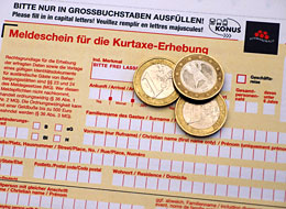 Meldeschein mit drei ein-Euro-Stücken