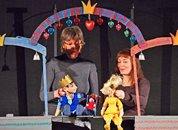 weiter zum Kinderpuppentheater in der Stadthalle. Puppenspieler mit König Handpuppe in der Kulisse