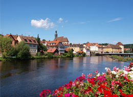 weiter zu Image-Film Murgtal Murgansicht: die Murg mit Blumen am Geländer, im Hintergrund die Altstadt Gernsbach