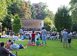 Konzert im Kurpark Besucher lauschen gemütlich auf Picknickdecken im Grünen einem Konzert im Kurpark